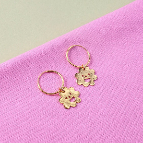Close up of gold Smiley Flower Hoops earrings