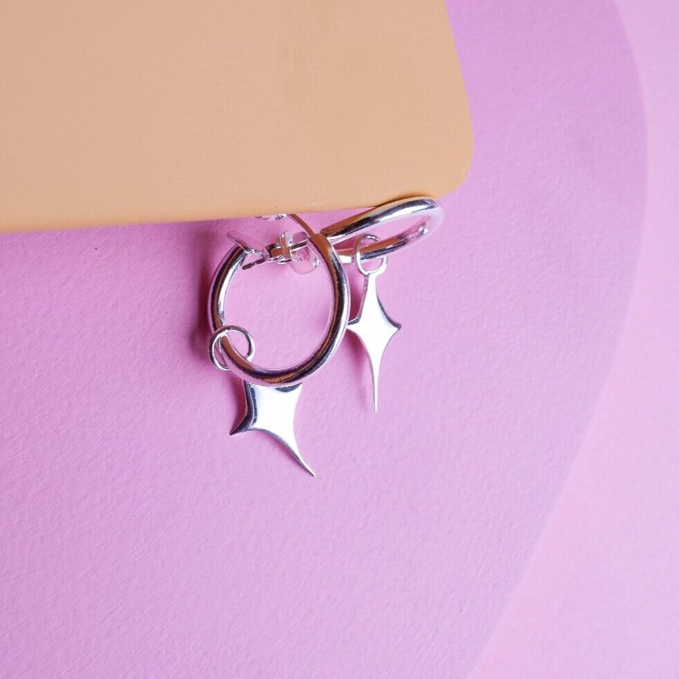 Small silver hoop earrings with a star shaped charm 