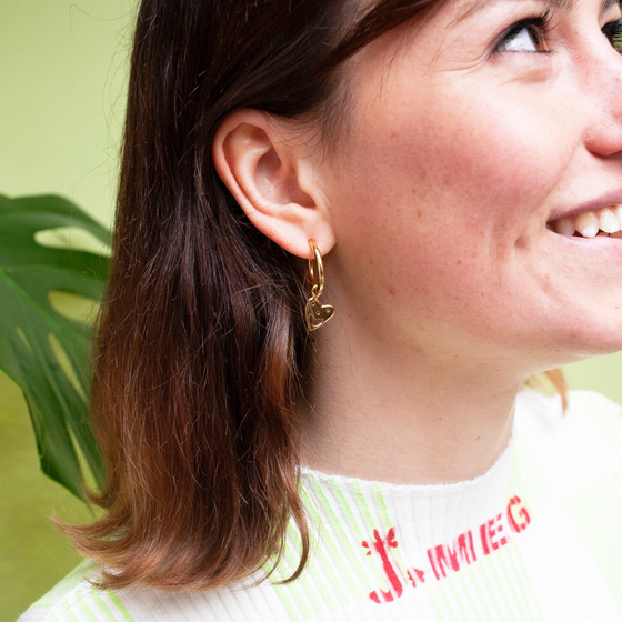 Close up of woman wearing gold Smiley Heart Hoops earring