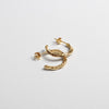 Close up of small gold hoop earrings with a textured surface