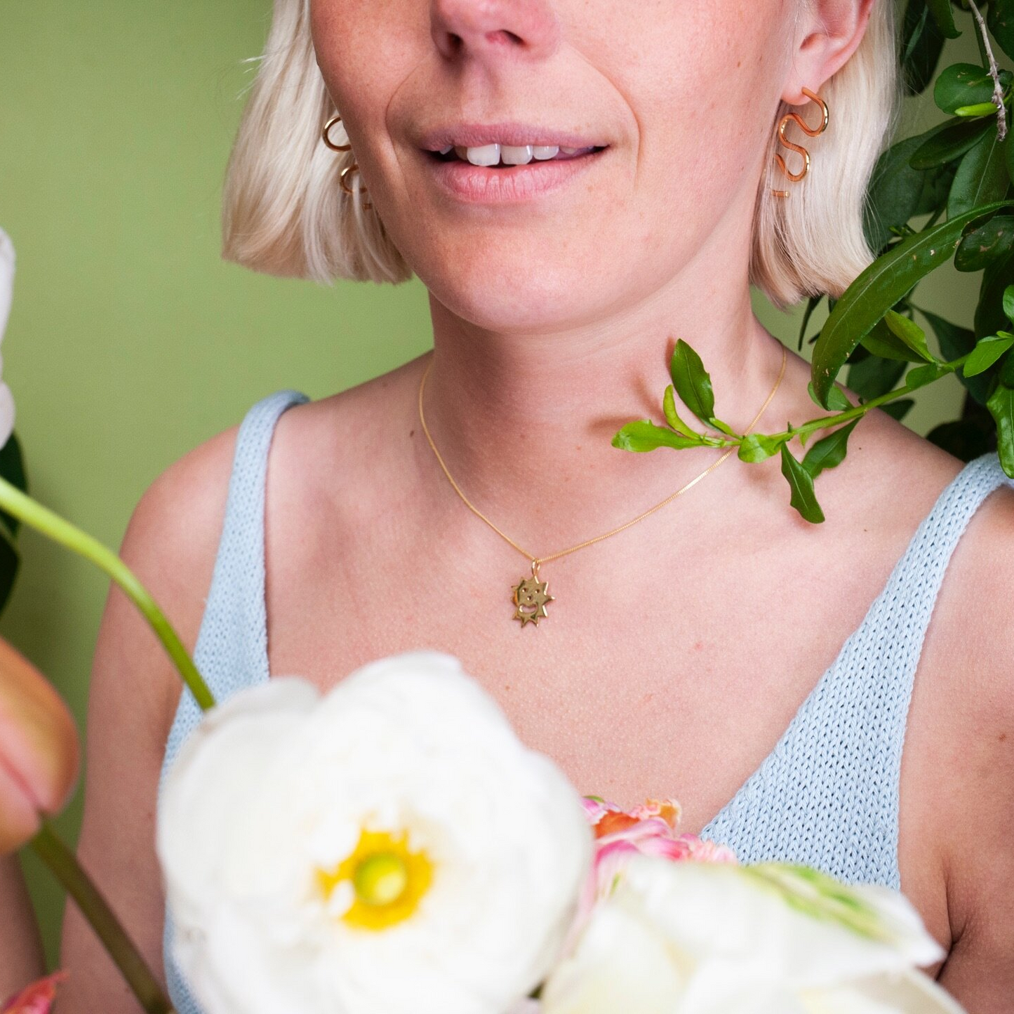 Woman wearing gold earrings in the shape of a squiggle