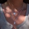 Pendant necklace with a silver abstract shape charm on it