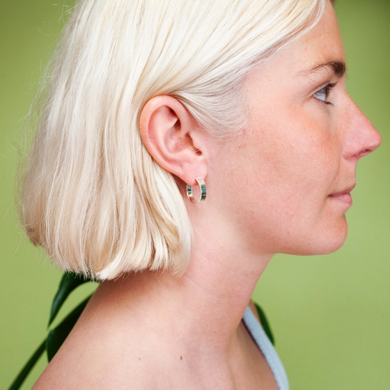 Woman wearing small, thick silver hoop earring