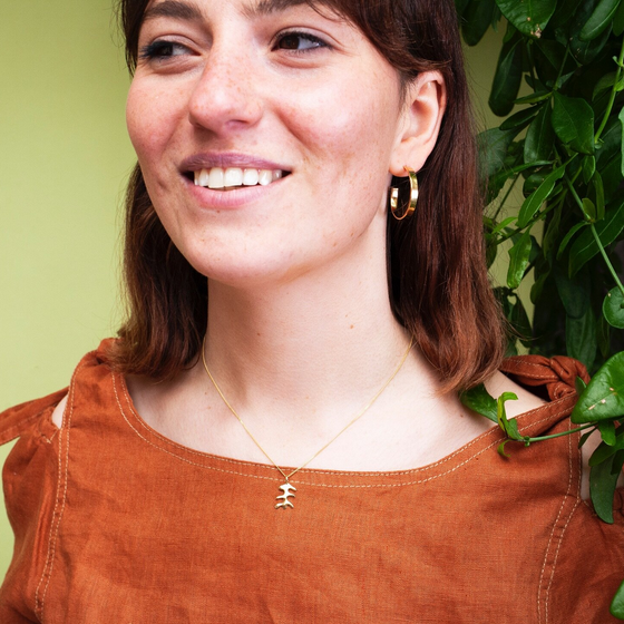 Woman wearing medium size flat hoop gold earrings