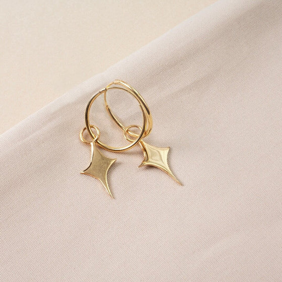 Small gold hoop earrings with a star shaped charm 