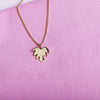 Close up of pendant necklace with a gold leaf shape charm on it