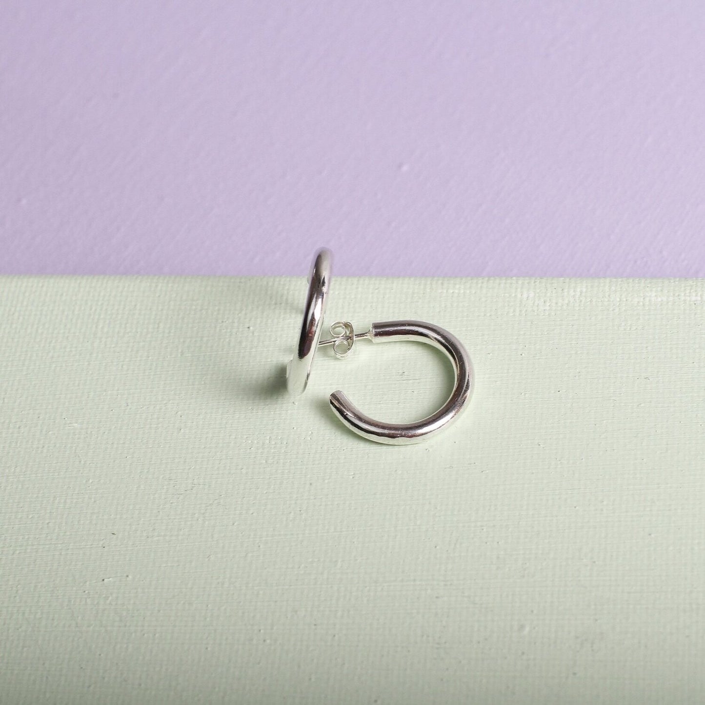 Close up of small silver hoop earrings