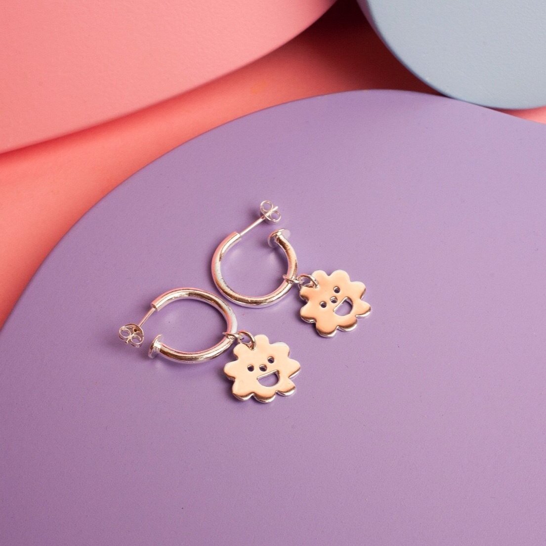 Close up of gold Smiley Flower Hoops earrings