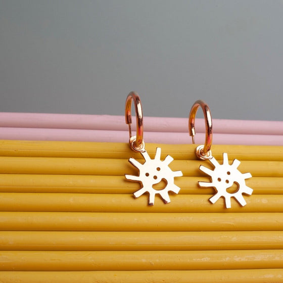 Close up of gold Smiley Sun Hoops earrings